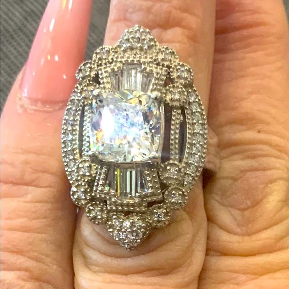 Stunning antique look setting. A cushion cut center stone with baguettes.Size6